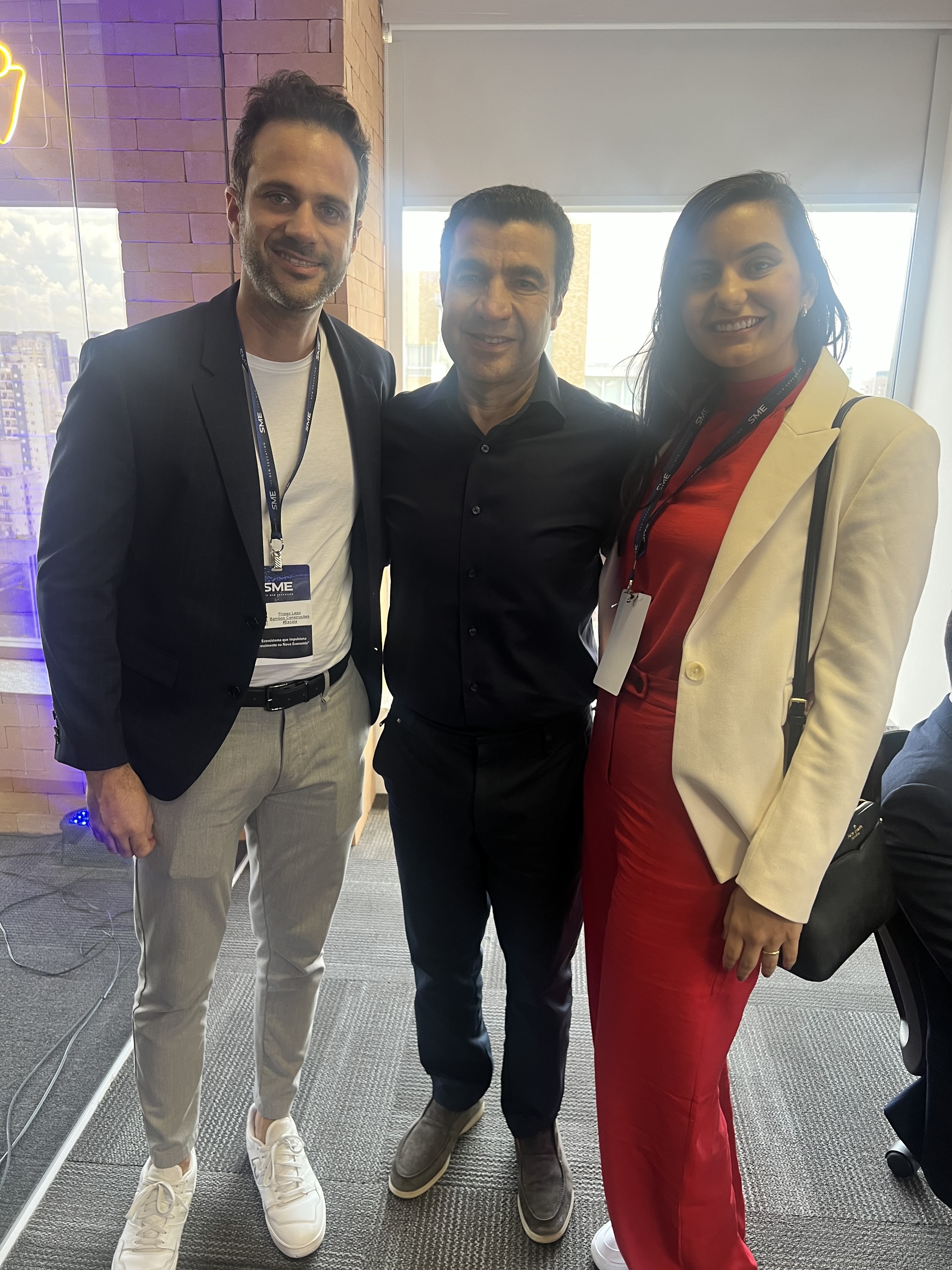 Thiago Lago em evento SME com dois participantes, todos com crachás do evento.