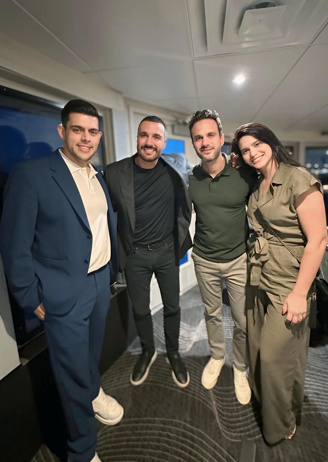 Thiago Lago em encontro noturno com três convidados, todos sorrindo posando juntos.